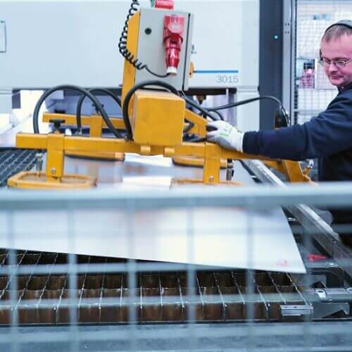 Worker loading sheet metal into a machine