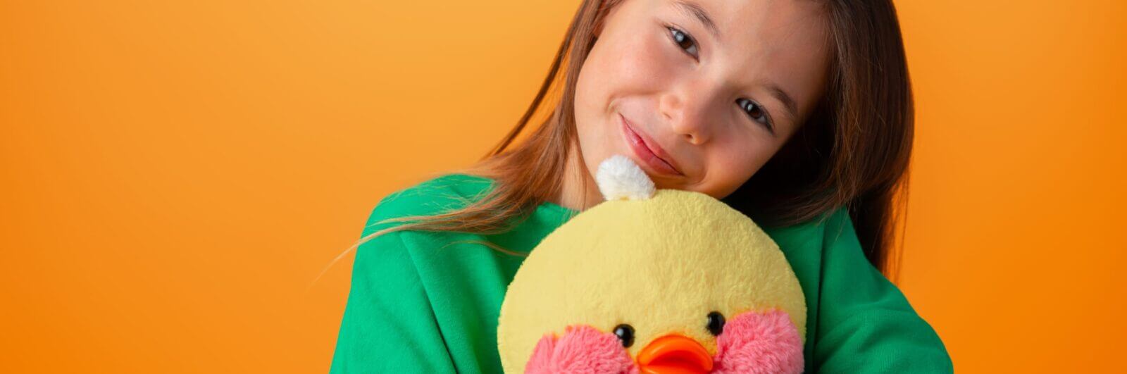 Pre-teen girl hugging a plush duck toy