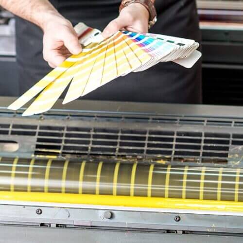 Commercial printer checking ink color against a swatch book