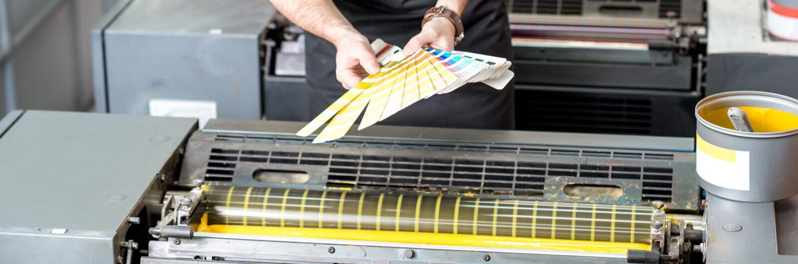 Commercial printer checking ink color against a swatch book