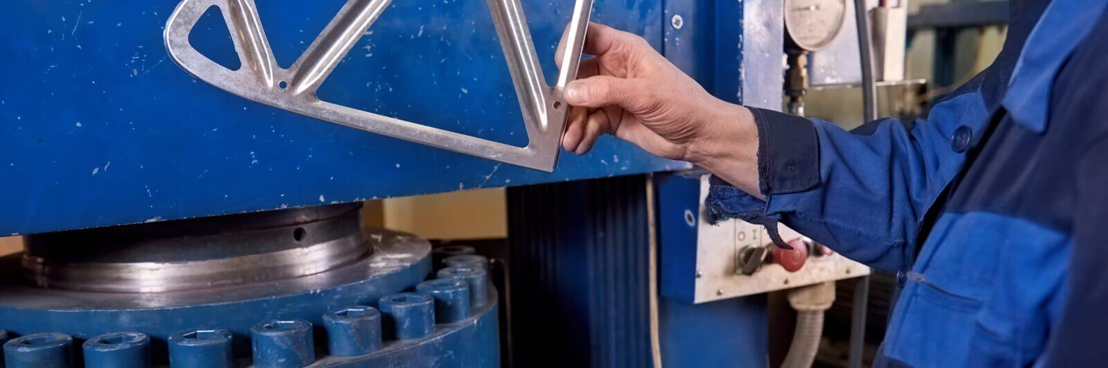 Worker inspects a stamped metal part