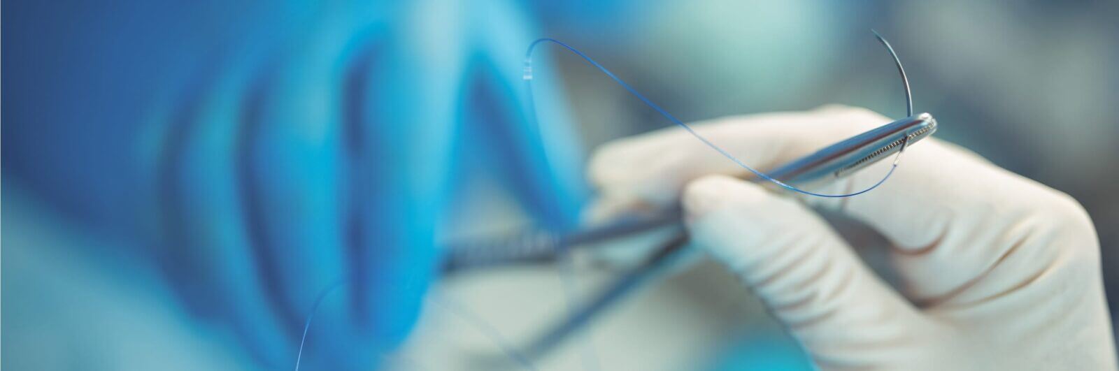 Surgeon holding small medical instruments