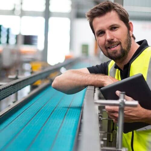 Worker inspecting a conveyor belt assembly