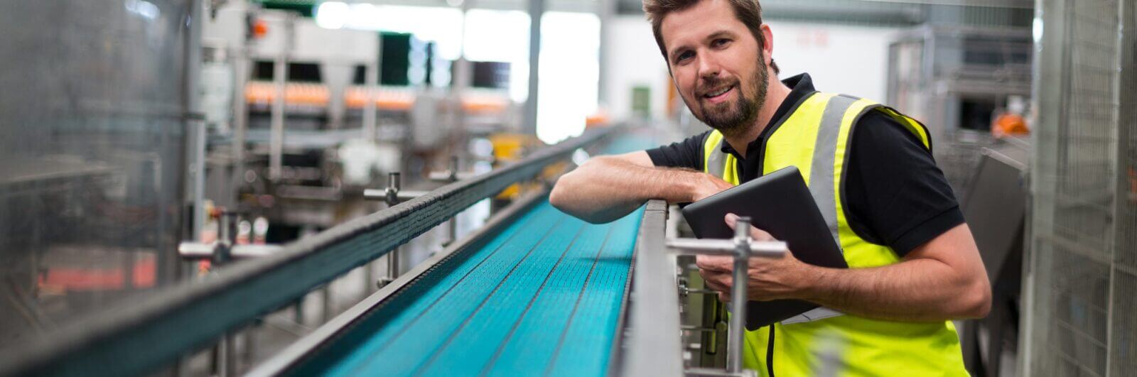 Worker inspecting a conveyor belt assembly
