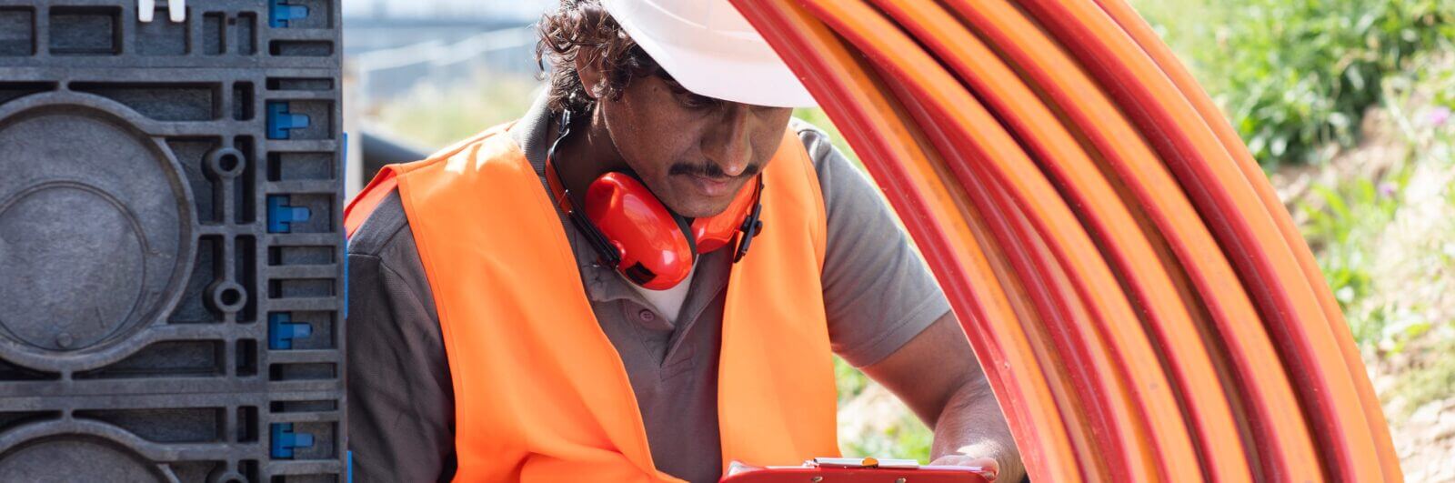 Worker installing underground telecommunications cable