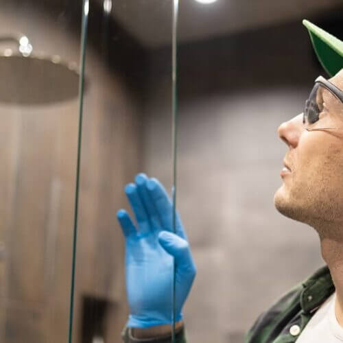 Worker installing a glass shower door